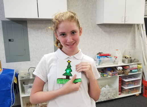 5th grade girl holding her light-up Christmas card
