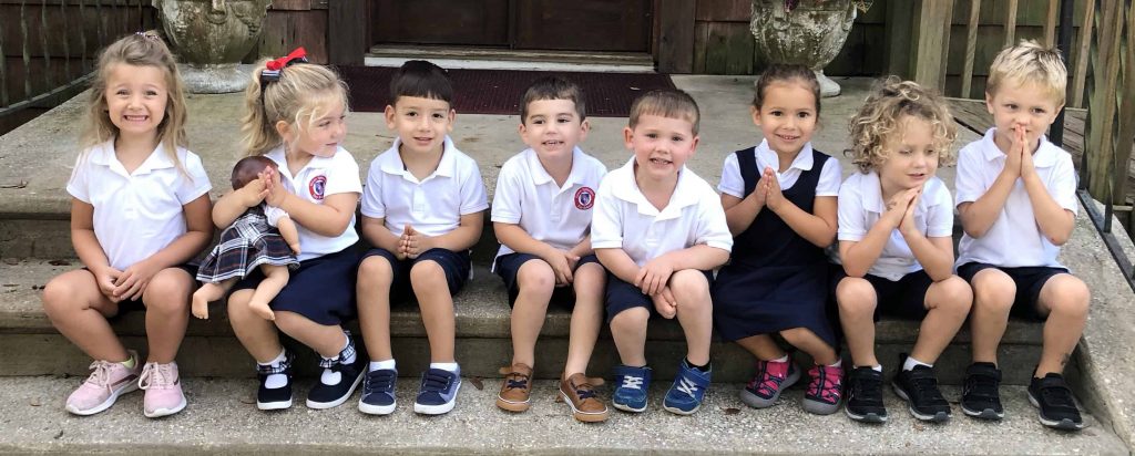 row of preschoolers sitting side by side