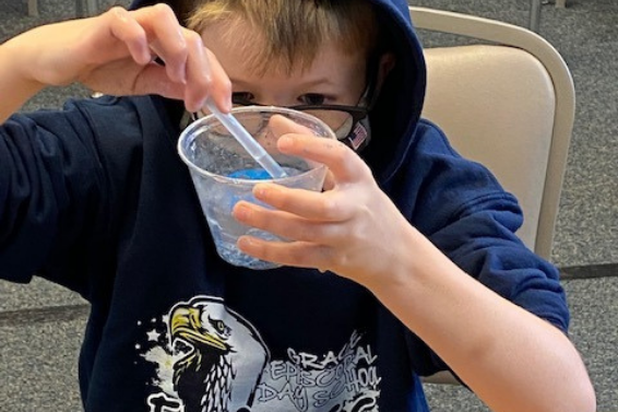 4th grade boy working with hydrophobic sand in a cup